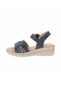 Sandal in suede blu con cinturino regolabile, caratterizzata da accenti argentati e una suola beige spessa per maggiore altezza e comfort.