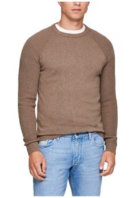 Brauner Strickpullover mit Rundhalsausschnitt, gerippter Textur und Raglanärmeln. Kombiniert mit hellblauen Jeans.