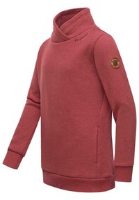 Punane särk volditud kaelusega, pikad varrukad ja ribidega mansetid. Vasakul varrukal on logo pa patch ja pehme kangatextuur.