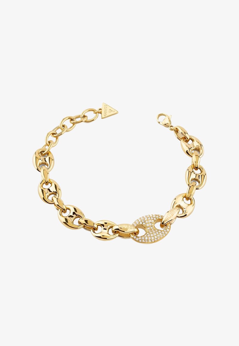 Bracelet chaîne en ton or avec de grands maillons ovales, un maillon incrusté de cristaux étincelants, et un pendentif triangulaire de marque sur fond blanc.