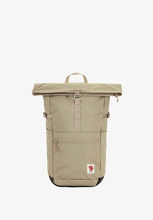 Sac à dos beige à rouleau avec poche zippée à l'avant, sangle à boucle centrale, sangles de compression latérales, poignée supérieure et logo renard rouge près de la base.