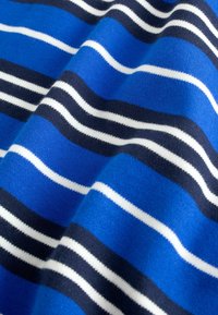 Fabric with horizontal stripes in blue, navy, and white, showing soft folds and a knit texture.