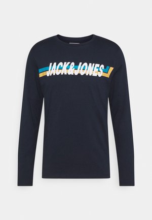 Granatowa koszula z długim rękawem z białym napisem „JACK & JONES” oraz niebiesko-żółtymi paskami na klatce piersiowej.