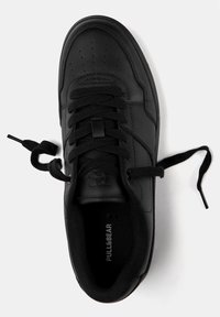 Czarny tenis z gładką skórzaną powierzchnią, okrągłym noskiem, wyściełanym kołnierzem i płaskimi czarnymi sznurowadłami. Posiada logo i teksturowaną podeszwę.