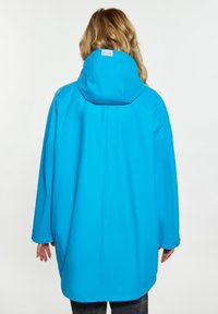 Jachetă impermeabilă de culoare albastră strălucitoare cu glugă, având o croială lejeră, mâneci lungi și o textură netedă. Vederea din spate arată detalii minime.