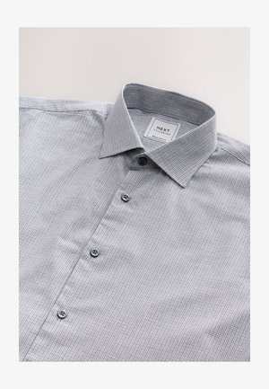 Šedá kostkovaná košile s límečkem na knoflíky, šedé knoflíky a štítek s nápisem "NEXT Tailoring, Regular Fit."