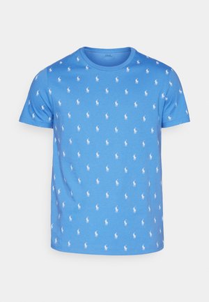 T-shirt en coton bleu avec un motif répété de joueurs de polo blancs, col rond et manches courtes. Coupe régulière avec une texture lisse.