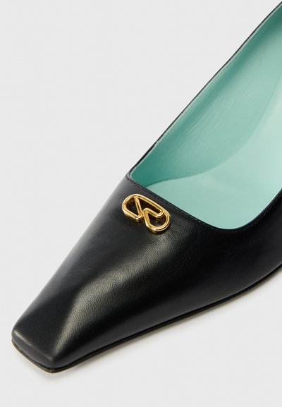 Μαύρο δερμάτινο ψηλοτάκουνο παπούτσι με μυτερή μύτη, που διαθέτει χρυσό λογότυπο και ανοιχτό μπλε εσωτερικό. Λείο υφή.