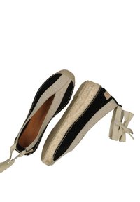 Czarno-beżowe espadryle z plecioną jutarową podeszwą, z teksturowanym materiałem górnym i wstążkami z tyłu dla pewnego dopasowania.