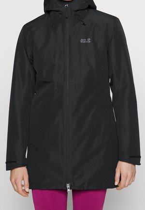 Zwarte waterdichte jas met capuchon en ritssluiting aan de voorkant, met "Jack Wolfskin" logo op de linkerborst, gedragen over felroze broek.