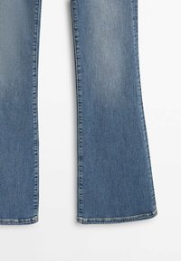 Moitié inférieure d'un jean en denim bleu avec coupe droite, léger délavage et ourlets cousus sur fond blanc.