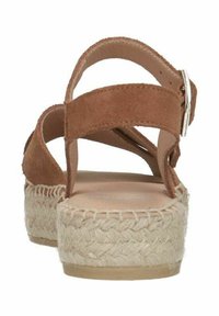 Brown suede platform sandals with two crisscross straps and a buckle closure. Dual-tone espadrille-style jute sole.