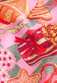Raštuotas audinys su raudonais ir geltonais ornamentais, dovanų dėžutėmis su kaspinėliais ir sausainių formomis ant rožinio fono su žaliais akcentais.