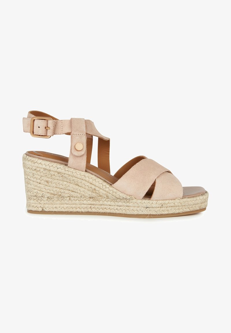 Sandale compensée en daim beige avec des brides croisées à l'avant, une bride à la cheville avec boucle et une semelle plateforme en corde tressée.