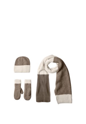 Conjunto de accesorios de invierno con gorro tejido beige y blanco, mitones a juego y una bufanda larga con diseño de bloques de color sobre fondo blanco.
