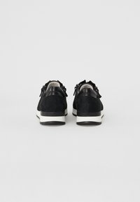 Baskets en suede noir avec des accents texturés et une semelle intermédiaire blanche. Le design présente un profil bas et un bout rond.