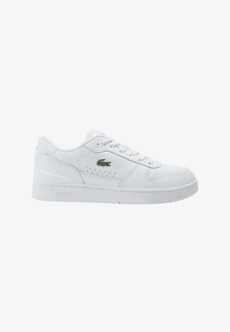 Valkoiset nahkakengät, joissa on rei'itetty muotoilu, tasainen valkoinen pohja ja vihreä Lacoste-alligaattori-logo sivussa. Nauhat ja pehmustettu kaulus ovat läsnä.