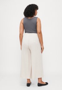 Gray sleeveless top, wide-leg linen-blend cream pants with elastic waist, and black flats. Smooth textures and relaxed fit.