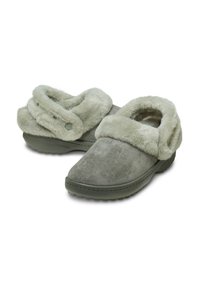 Zapatillas de ante gris con un puño de piel de peluche verde, con forma redondeada y una suela texturizada para mayor agarre. Detalle de botón ajustable presente.