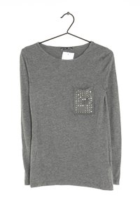 Langärmliges graues T-Shirt mit Rundhalsausschnitt und einer dekorativen Tasche mit silbernen Nieten im linken Brustbereich.