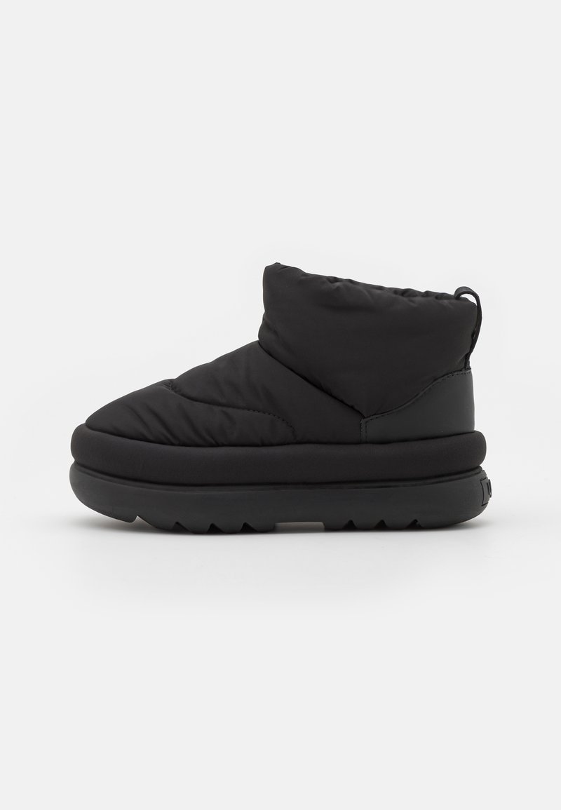Botas tobilleras negras y acolchadas con punta redonda, hechas de tejido acolchado y suela de goma, con un talón elevado y fondo texturizado para mayor agarre.