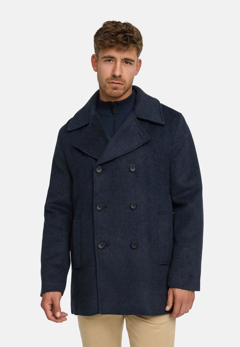 Abrigo de lana navy tipo peacoat con cierre de doble botonadura, solapas grandes y botones negros. Cuenta con bolsillos laterales y un corte relajado.