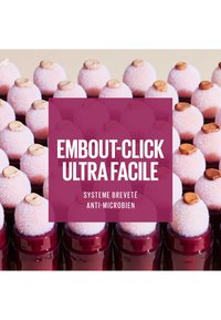 Applicateurs de maquillage avec des embouts rose doux et des caps de produit beige, logés dans des contenants rouges brillants, dotés d'une technologie antimicrobienne.