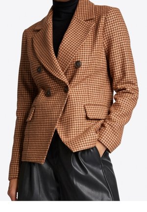 Bruine houndstooth dubbelzijdige blazer met notch lapels, donkere knopen en twee voorzakken, gecombineerd met zwarte leren broeken.