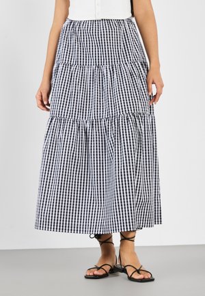 Svart og hvit gingham maxi skjørt, lagdelt design med rynkede detaljer, laget av lettvektig stoff, kombinert med svarte sandaler med stropper.