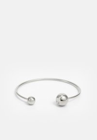 Brazalete de metal plateado con dos acentos esféricos en cada extremo, superficie lisa, diseño abierto y forma elegante y minimalista.