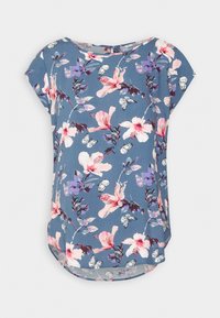 Blomstrig kortärmad topp i blått tyg med rosa och lila blommönster, fjärilsdetaljer och rundad nederkant.