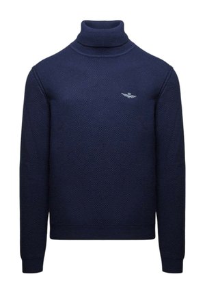 Maglione a collo alto color navy in tessuto strutturato con maniche lunghe. Presenta un piccolo logo argentato sul petto. Vestibilità classica e polsini a costine.