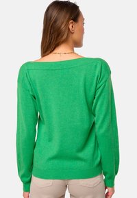 Grüner Strickpullover mit weitem Ausschnitt, langen Ärmeln und geripptem Saum. Weiche Textur und lässige Passform, von hinten gezeigt.