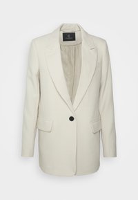 Blazer crème à un bouton avec revers crantés et poches à rabat, doté d'une doublure intérieure lisse et d'une coupe ajustée.