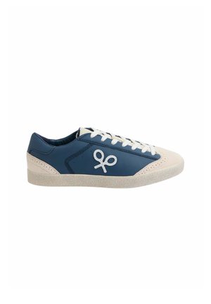 Zapatilla baja con laterales de cuero azul, puntera y talón beige, cordones blancos y un logo blanco que se asemeja a unas tijeras en el lateral.