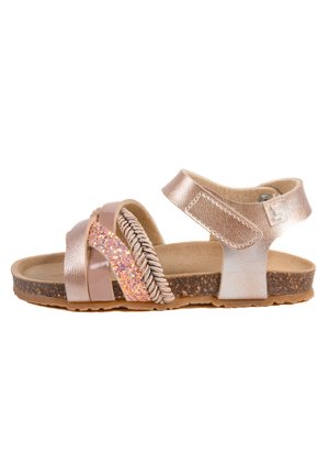 Sandale à semelle en liège brun avec des brides métalliques multicolores, y compris une section en paillettes roses et un accent argenté. Fermeture Velcro au niveau de la cheville.