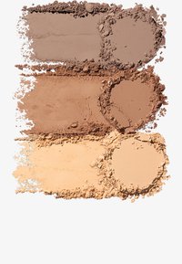 Trois teintes de poudre pressée disposées horizontalement : taupe froid, marron chaud et beige clair. Chacune présente une texture lisse avec des bords distincts.