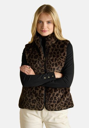 Leopardenfellweste mit hohem Kragen, Reißverschluss und gestuftem Design, kombiniert mit einem schwarzen Langarmshirt und cremefarbenen Hosen.