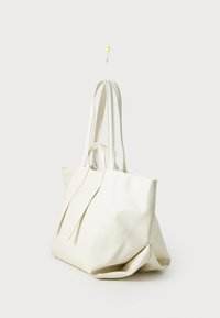 Biała torba tote o gładkiej teksturze, z długimi uchwytami i złożonym designem. Brak widocznych elementów metalowych lub akcentów, idealna do codziennego użytku.