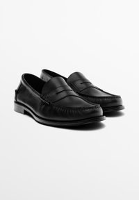 Schwarze Leder-Loafers mit elegantem Design, inklusive einer genähten Vorderkappe und kleinem Absatz. Glatte Oberfläche mit schlichten Details am Obermaterial.