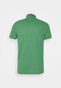 T-shirt polo vert avec un col court, des manches courtes et une texture lisse. Il présente un design simple, uni, sans motifs ni embellissements.