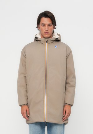 Beige hooded jack met een ritssluiting aan de voorkant, meerkleurige ritssluitingaccenten en een zachte, gevoerde binnenkant. Twee zijzakken en elastische manchetten.