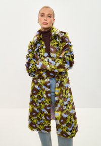 Cămașă din blană sintetică cu un model floral în verde, albastru și maro. Prezintă un guler larg, mâneci lungi și un design până la genunchi. Finisaj texturat.