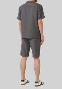 Korte mouwen grijs met een tonaal patroon shirt en bijpassende shorts, gemaakt van lichtgewicht stof, met een relaxte pasvorm en een vlakke tailleband.