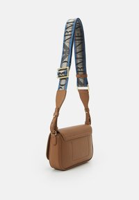 Brązowa skórzana torba na ramię z teksturowaną powierzchnią, z niebieskim paskiem z nadrukiem logo, regulowanym zapięciem i płaską kieszenią z przodu.