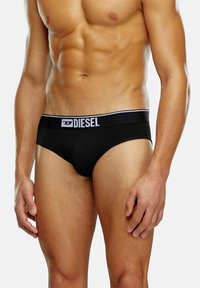 Schwarze Baumwollslips mit einem weißen Bund, der das "DIESEL"-Logo trägt. Das Design ist eng anliegend und figurbetont.
