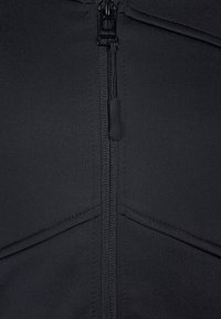 Czarny, zapinany na zamek ubiór o gładkiej fakturze, z detalami szwów i centralnym zamkiem błyskawicznym z suwakiem. Materiał wydaje się lekki i elastyczny.