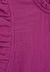 Tessuto viola con un bordo arricciato, con una finitura testurizzata. Il materiale sembra leggero, adatto per indumenti.