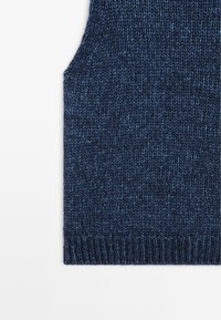 Dzianinowy granatowy sweter bez rękawów z teksturowanym wzorem, z okrągłym dekoltem i otwartymi delikatnymi rękawami, zakończony ściągaczem.