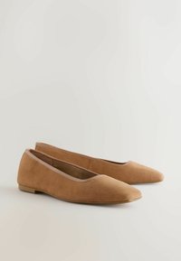 Brune ruskind ballet flats med spids tå, glat tekstur og en tynd beige kant langs åbningen. Flad sål og minimalistisk design.